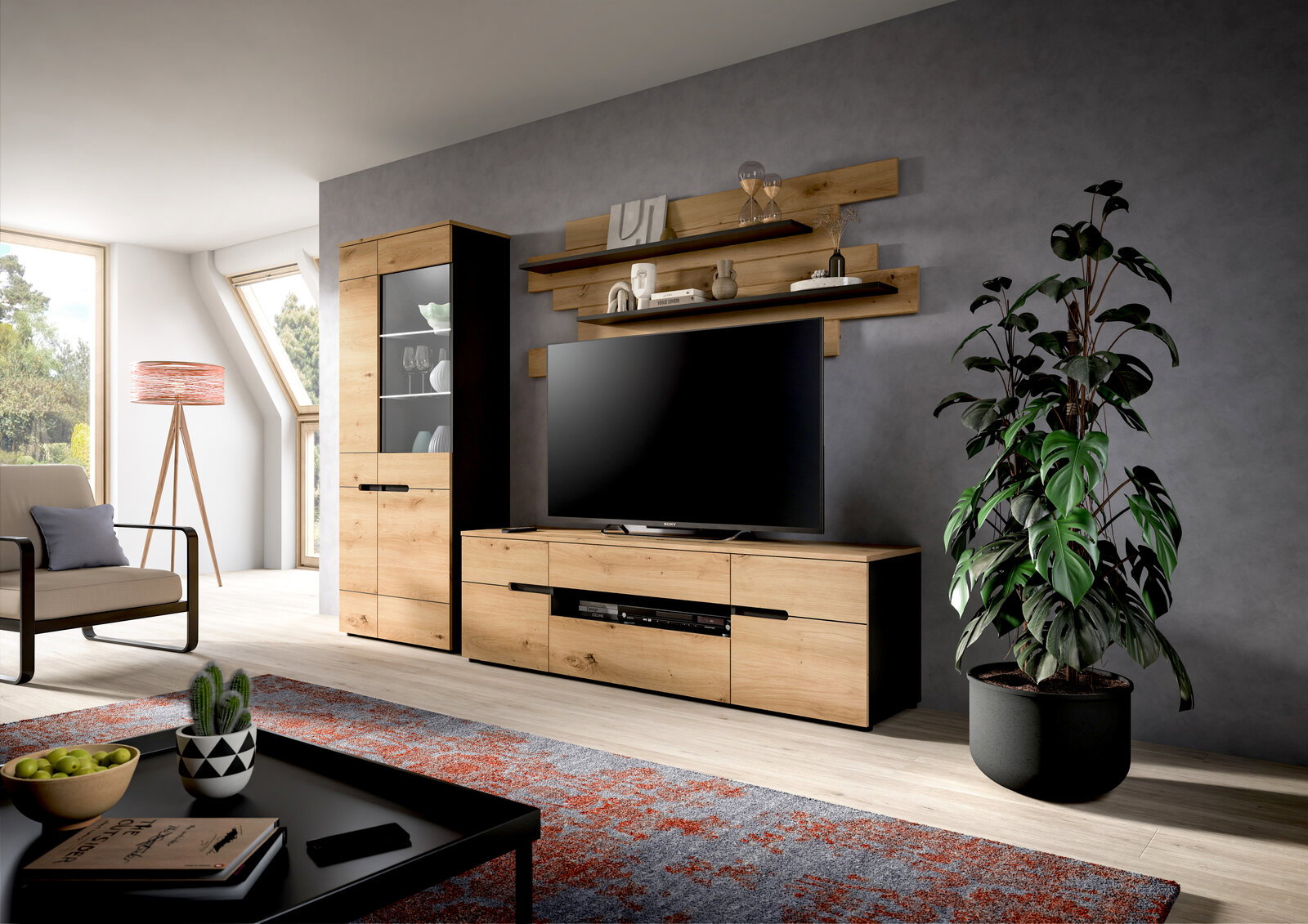 Modernes Wohnzimmer mit TV-Wohnwand in Eiche-Optik und schwarzen Akzenten, bestehend aus Lowboard, Vitrine und Wandregalen, frontal aus leicht schräger Perspektive aufgenommen.