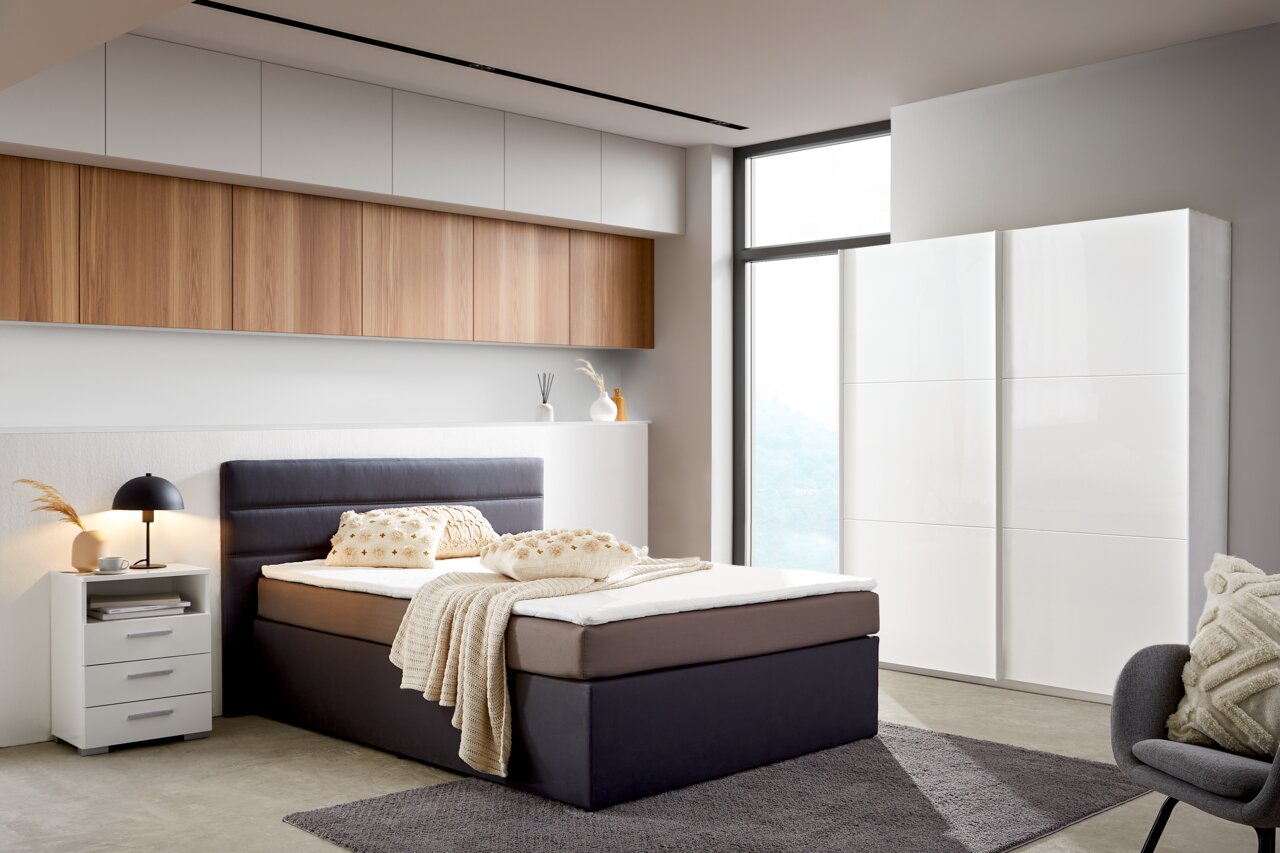 Ti´me Schwebetürenschrank 2-türig LAUSANNE PLUS Moderner, weißer Schwebetürenschrank mit zwei Türen in einem stilvoll eingerichteten Schlafzimmer, seitliche Perspektive.