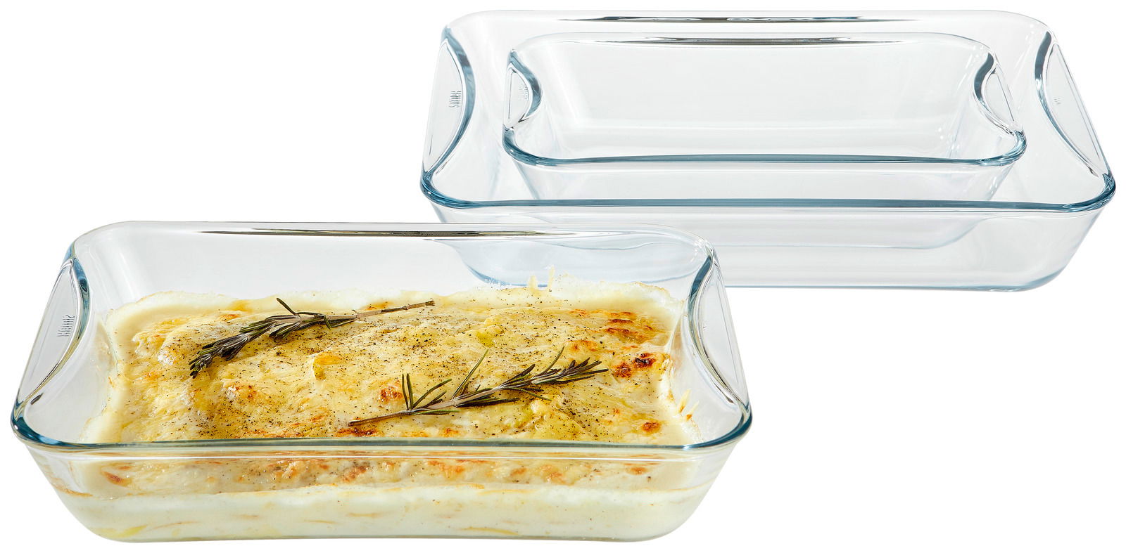 Set aus drei transparenten Brat- und Backschalen, eine mit gratiniertem Gericht gefüllt, aus seitlicher Perspektive fotografiert.