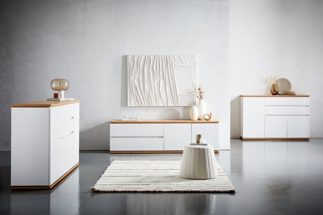Moderne Wohnzimmermöbel in Weiß mit Holzoberfläche, bestehend aus Kommode, Sideboard und TV-Lowboard, aus frontaler Perspektive fotografiert.