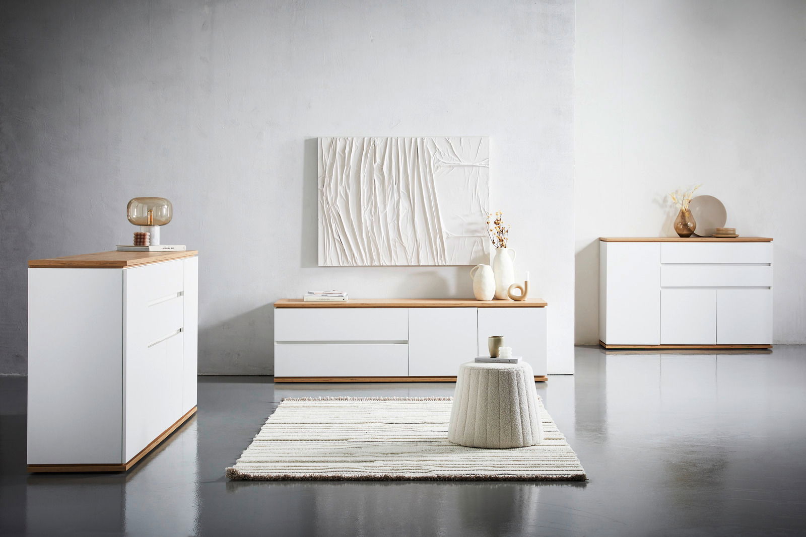 Moderne Wohnzimmermöbel in Weiß mit Holzoberfläche, bestehend aus Kommode, Sideboard und TV-Lowboard, aus frontaler Perspektive fotografiert.