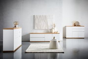 Moderne woonkamermeubels in wit met houten afwerking, bestaande uit een ladekast, een dressoir en een tv-kast, gefotografeerd vanuit vooraanzicht.