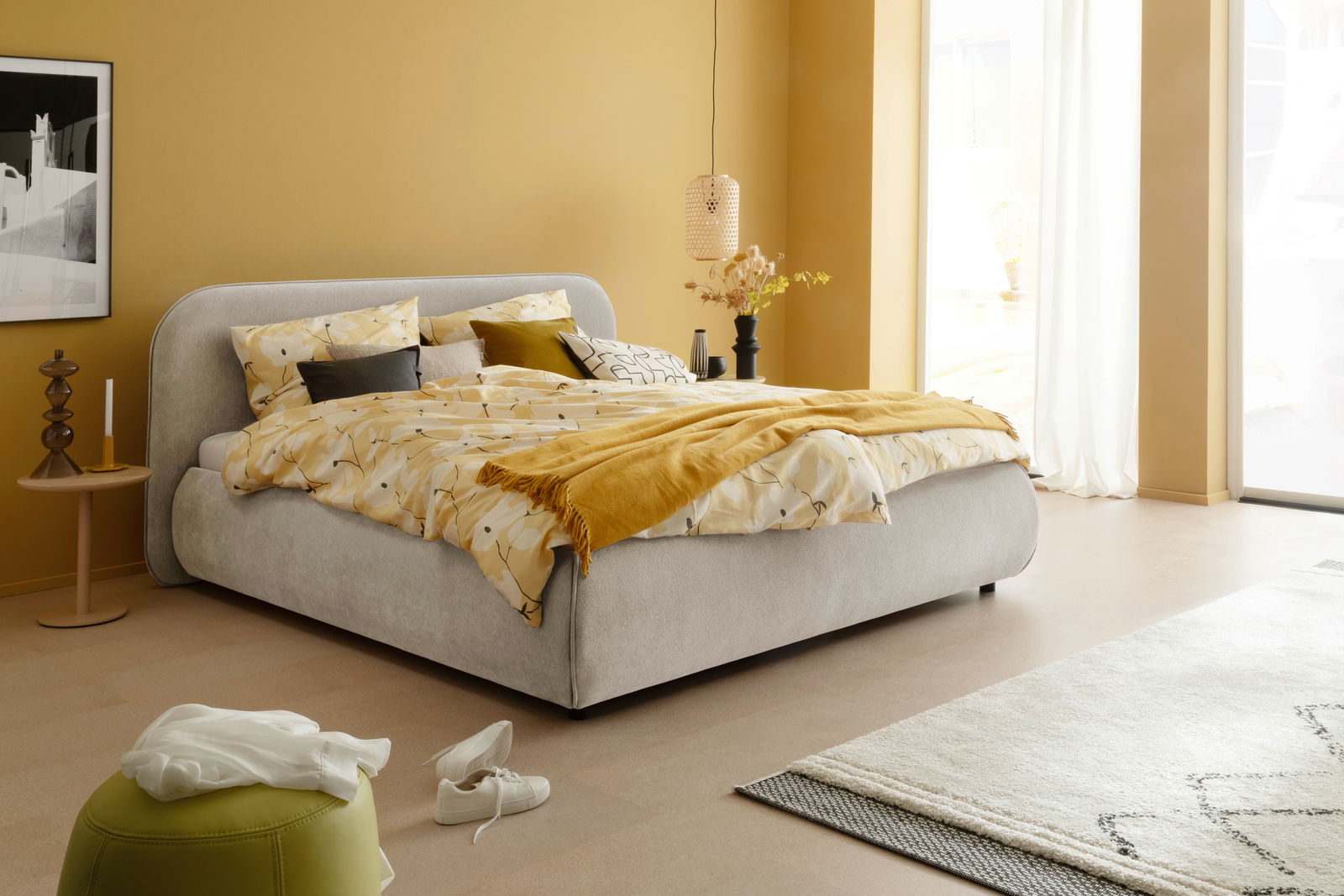 Gemütliches Polsterbett LISSABON in einem modern eingerichteten Schlafzimmer, seitliche Perspektive.