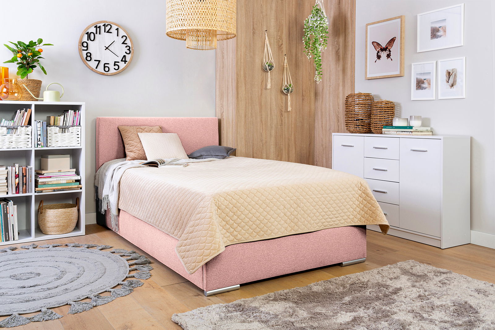 Boxbett 140 in einem gemütlichen Schlafzimmer mit rosa Polsterung, beige Steppdecke und moderner Dekoration, seitliche Perspektive