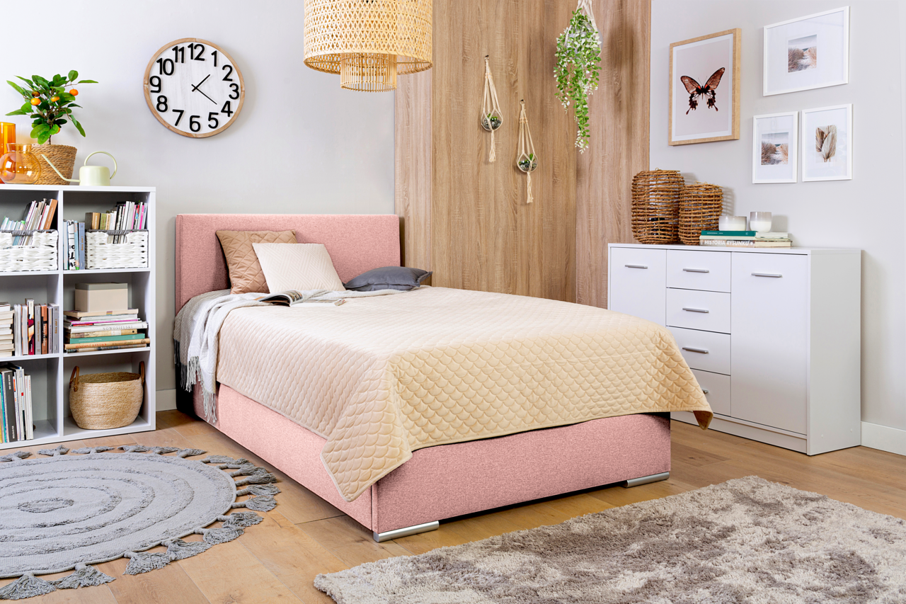 Boxbett 140 in einem gemütlichen Schlafzimmer mit rosa Polsterung, beige Steppdecke und moderner Dekoration, seitliche Perspektive