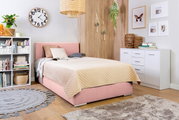 Boxbett 140 in einem gemütlichen Schlafzimmer mit rosa Polsterung, beige Steppdecke und moderner Dekoration, seitliche Perspektive