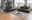 Modernes Wohnzimmer mit zwei schwarzen 3er-Sofas in einer urbanen Umgebung, Blick aus der Ecke des Raumes.