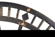 Close-up van een antiek ogende wandklok met Romeinse cijfers en een rustieke, metalen afwerking.