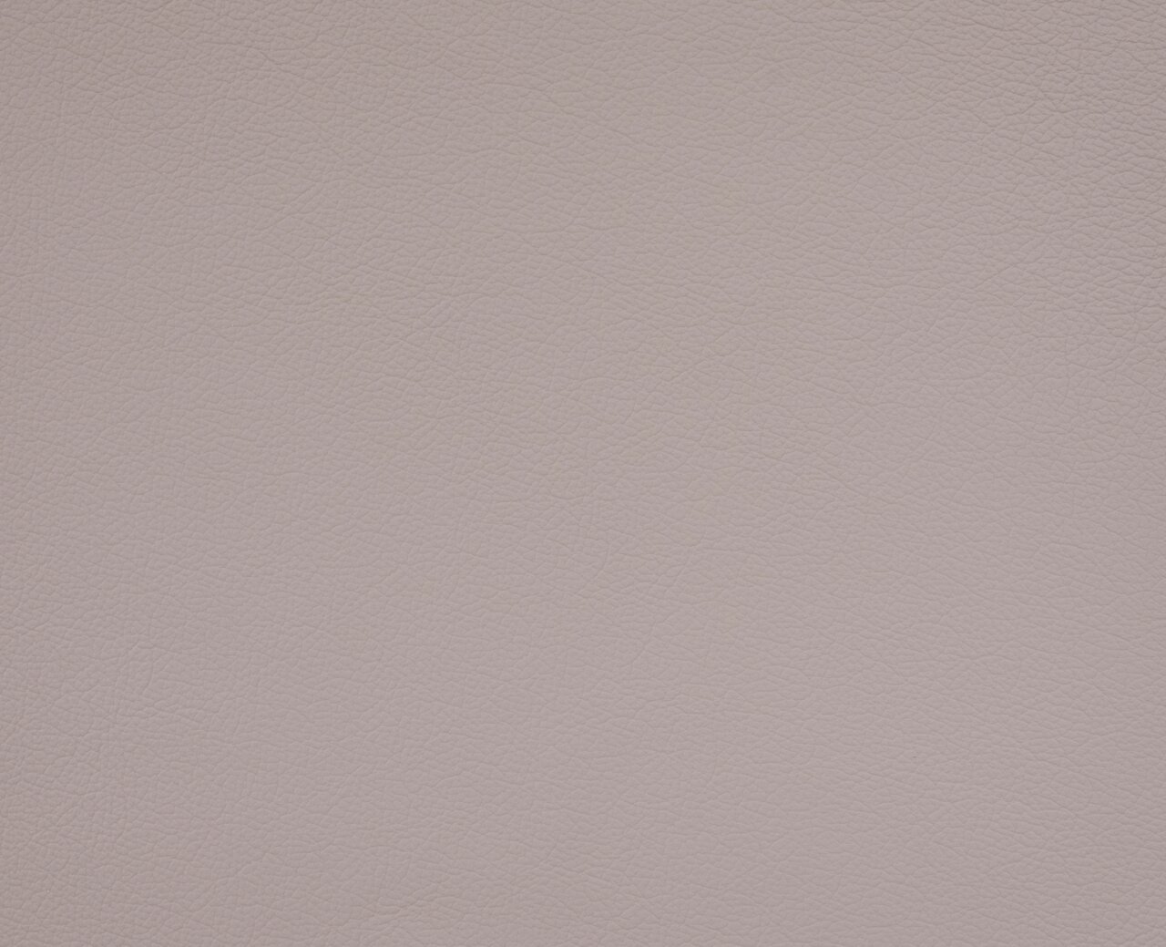 Nahaufnahme der Textur eines hellen, lederartigen Materials, das für einen Chefsessel verwendet wird.