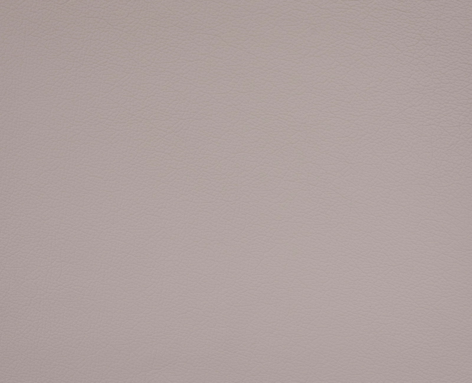 Nahaufnahme der Textur eines hellen, lederartigen Materials, das für einen Chefsessel verwendet wird.