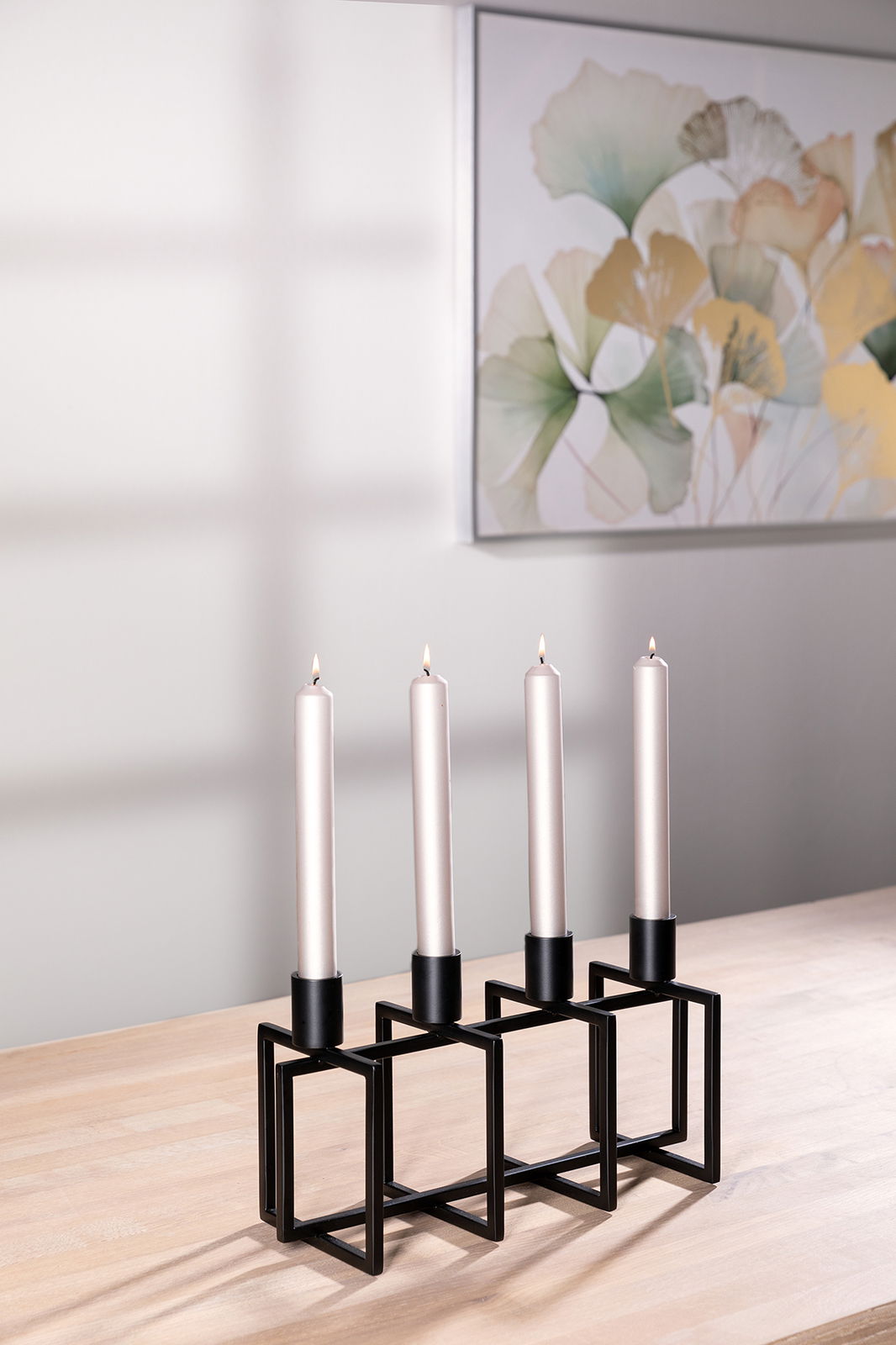 Fink Leuchter 4-flg. ELLIOT Moderner 4-flammiger Kerzenhalter aus schwarzem Metall mit geometrischem Design, auf einem Holztisch stehend, seitliche Perspektive.