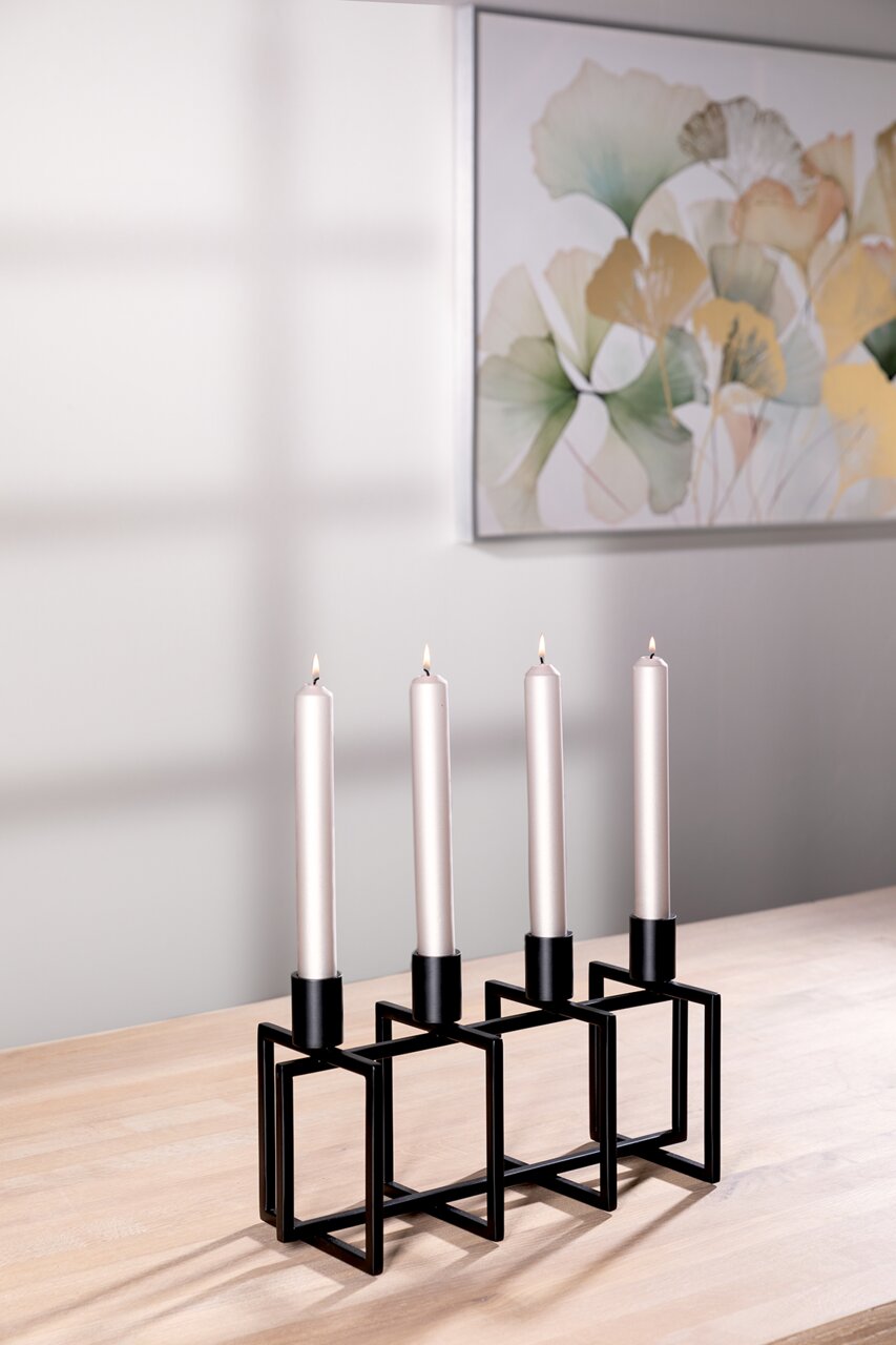 Moderner 4-flammiger Kerzenhalter aus schwarzem Metall mit geometrischem Design, auf einem Holztisch stehend, seitliche Perspektive.