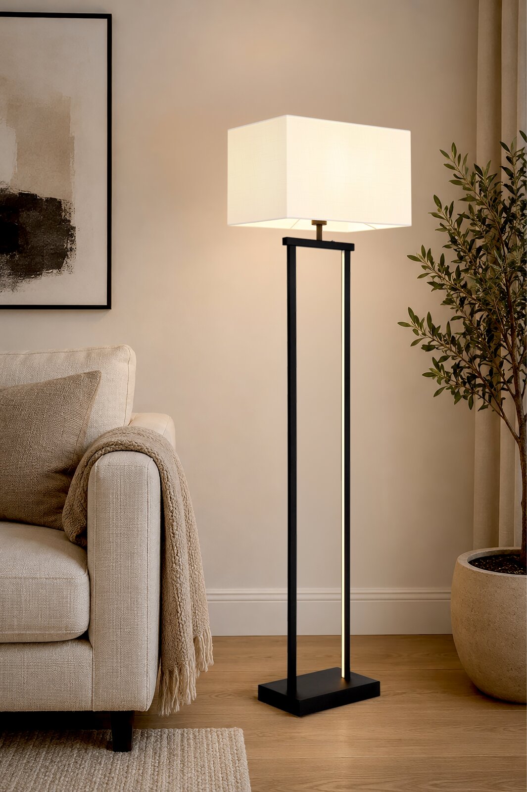 Moderne schwarze Stehlampe mit quadratischem weißem Stoffschirm, eingeschaltet neben einem beigen Sofa im Wohnzimmer; Perspektive: frontale, leicht seitliche Ansicht in Raumumgebung.