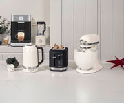 Küchenmaschine, Wasserkocher, Toaster und Kaffeevollautomat in einer modernen Küche, seitliche Perspektive