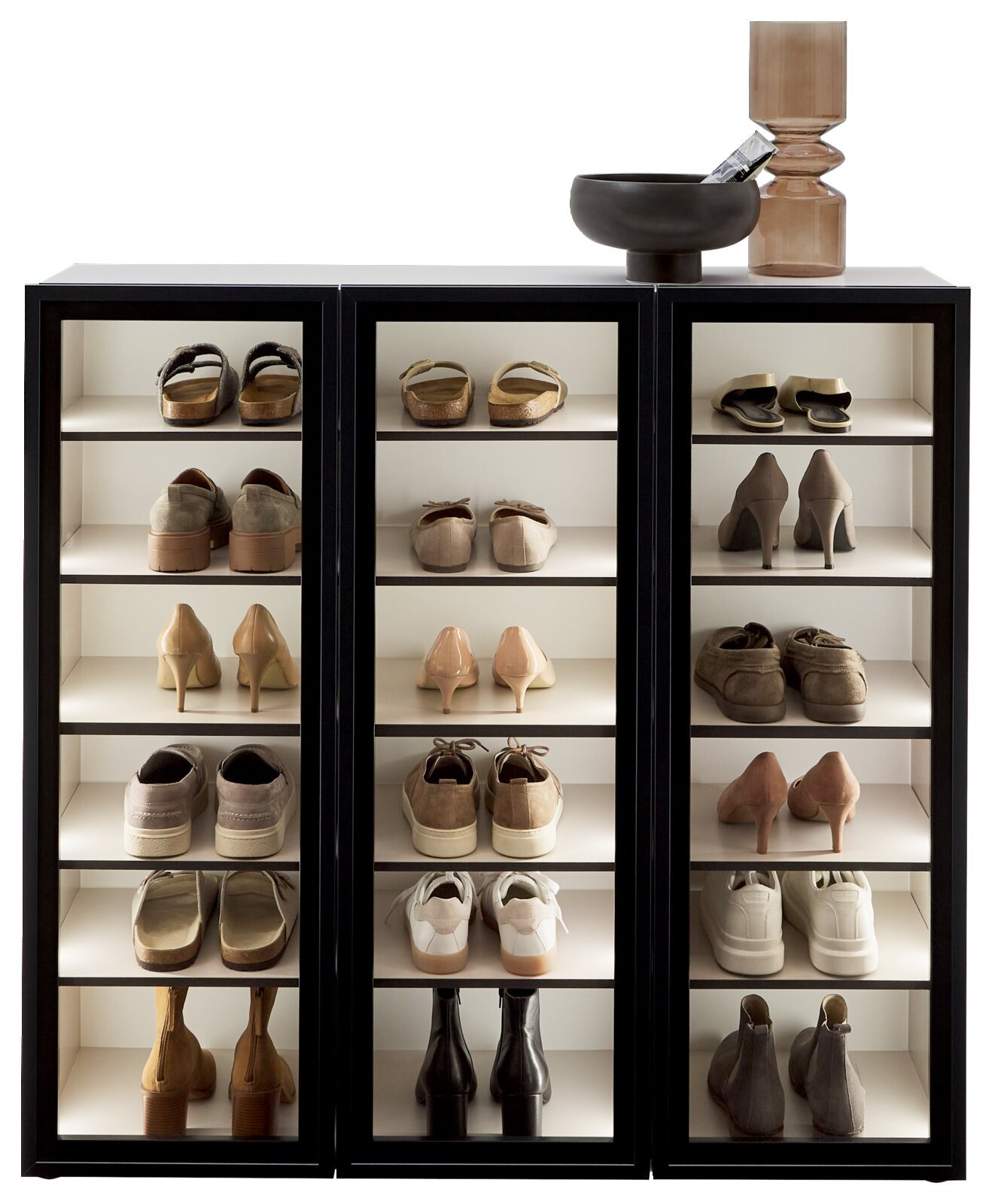 Schuhschrank-Vitrine mit drei Abschnitten, gefüllt mit verschiedenen Schuhen, aus der Frontalperspektive.
