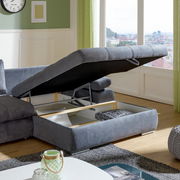 Graues Ecksofa mit Stauraum, geöffnete Ottomane, Tageslicht, Stadtblick im Hintergrund, Perspektive von der Seite