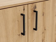 Nahaufnahme einer Kommode aus hellem Holz mit zwei schwarzen, modernen Griffen. Perspektive von vorne.