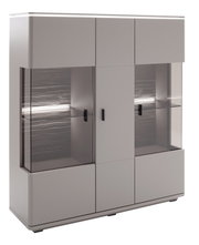 Moderne graue Vitrine/Highboard mit Glasfronten, schwarzen Griffen und integrierter LED-Beleuchtung, gezeigt in leichter Frontansicht (3/4-Perspektive) vor weißem Hintergrund