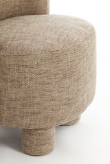 Nahaufnahme eines Sessels mit beigem Stoffbezug und runden Beinen, seitliche Perspektive.