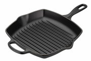 Zwarte gietijzeren grillpan met groeven, vierkante vorm, handvatten aan de zijkanten en aan de lange zijden, aanzicht van bovenaf.