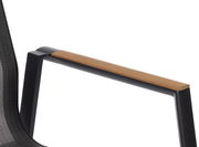 Nahaufnahme eines Stapelstuhls mit schwarzem Rahmen und Holzarmlehne, seitliche Perspektive