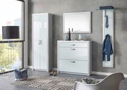 Moderne Garderobeneinrichtung mit weißem Schuhschrank, Spiegel und Garderobenpaneel in einem hellen Raum, seitliche Perspektive.