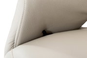 Nahaufnahme eines beigen Relaxsessels aus Leder mit Fokus auf die Naht und den Hebel an der Seite.