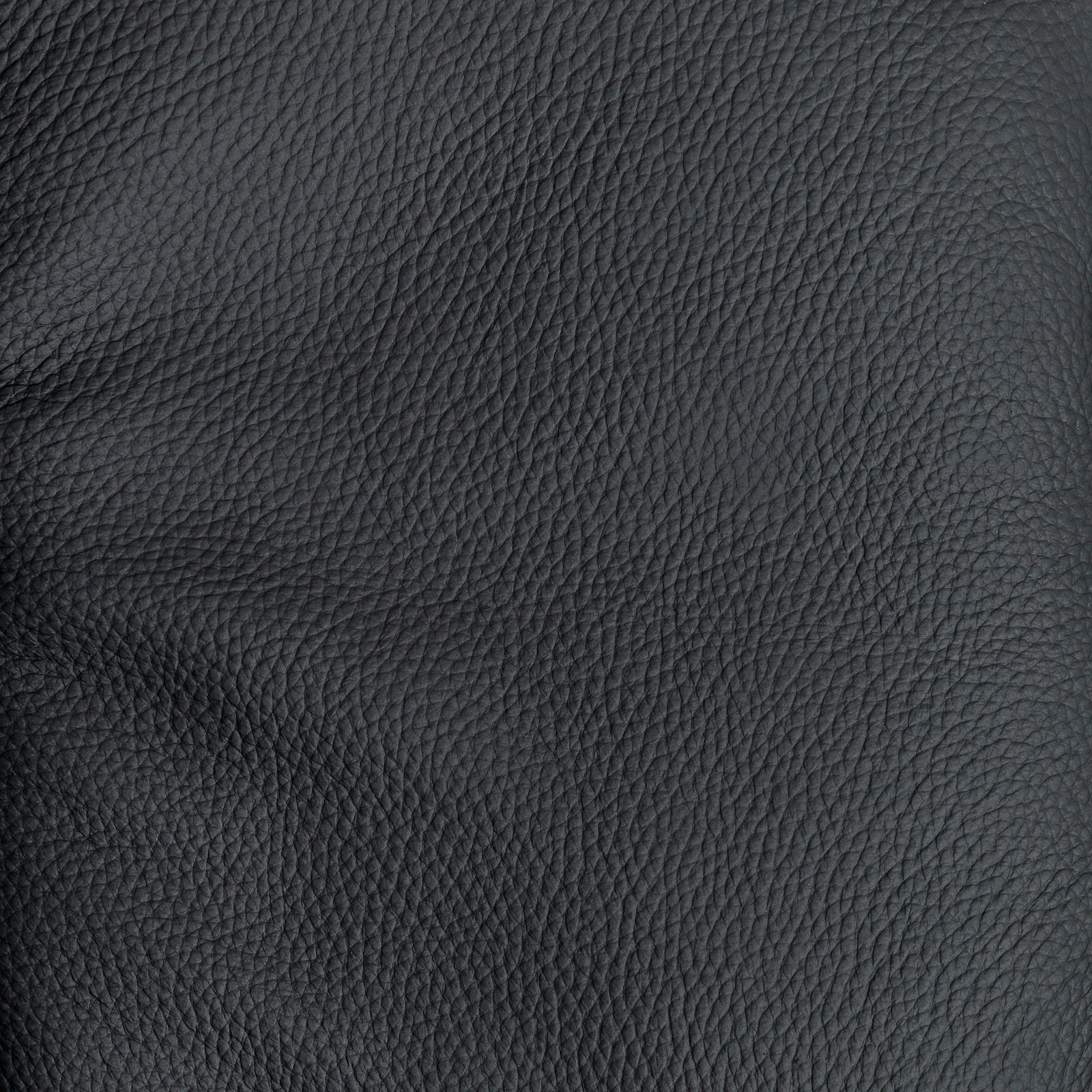 Nahaufnahme der schwarzen Lederstruktur eines Relaxsessels, perspektivisch von oben betrachtet.