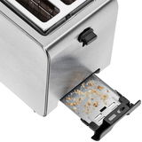 Nahaufnahme eines WMF Stelio Toasters mit herausgezogener Krümelschublade, die Krümel zeigt.