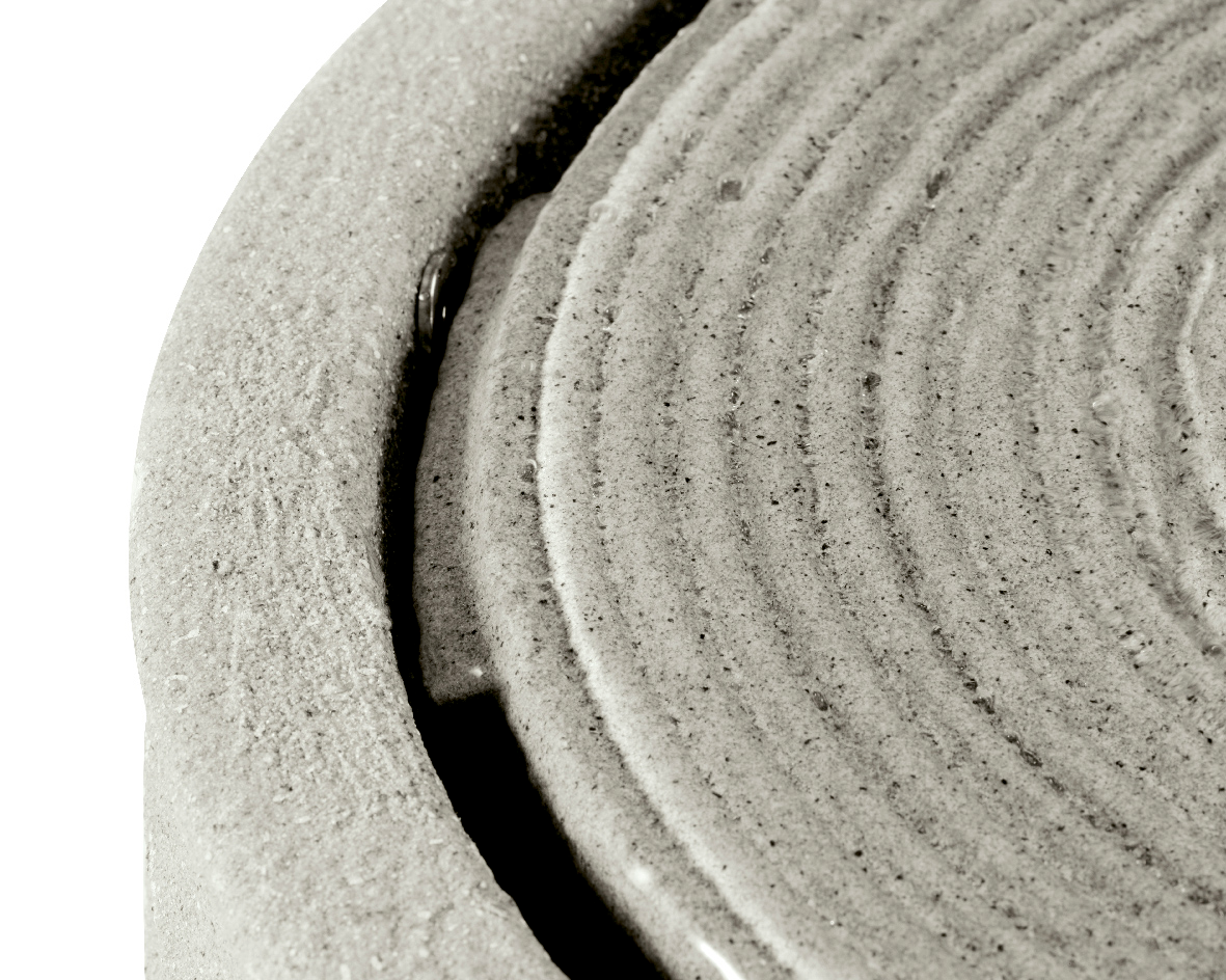 Nahaufnahme eines runden, strukturierten Objekts aus recyceltem Kunststoff mit konzentrischen Kreisen, von oben betrachtet.