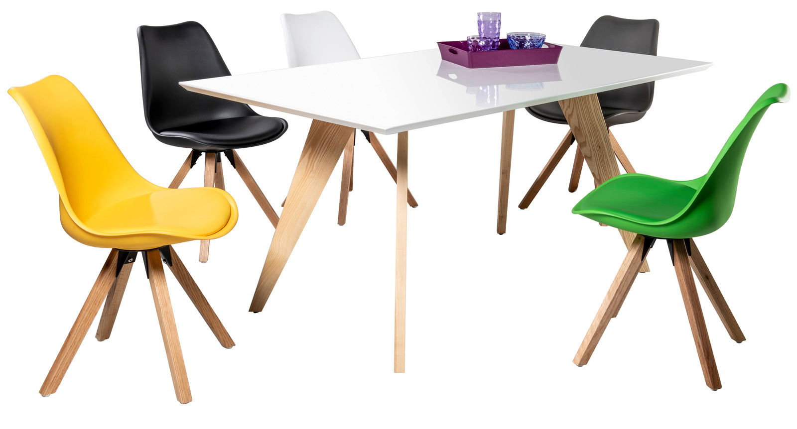 Essgruppe mit einem weißen Tisch und bunten Stühlen in gelb, schwarz, weiß, grau und grün, aus seitlicher Perspektive.