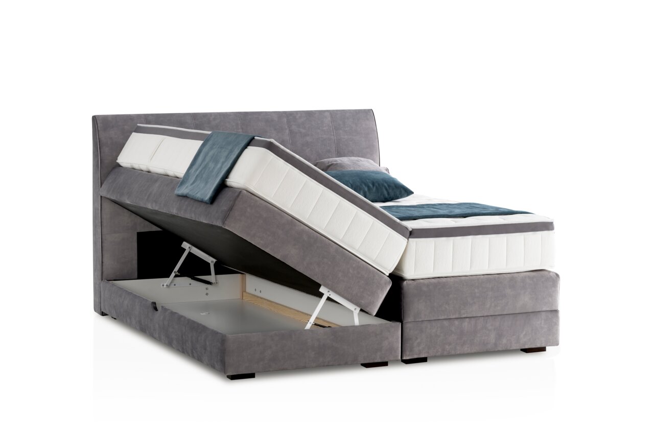 Boxspringbett in seitlicher Perspektive mit geöffnetem Bettkasten und grauem Stoffbezug.