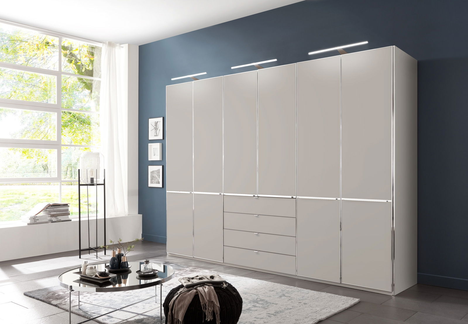 Moderner Funktionsschrank in einem stilvollen Wohnzimmer, frontal betrachtet, mit mehreren Türen und Schubladen, beleuchtet von eleganten Leuchten.