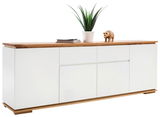 Modernes XL-Sideboard CHIARO mit weißer Front und Holzoberfläche, dekoriert mit einer Pflanze und einer Holzfigur, seitliche Perspektive.