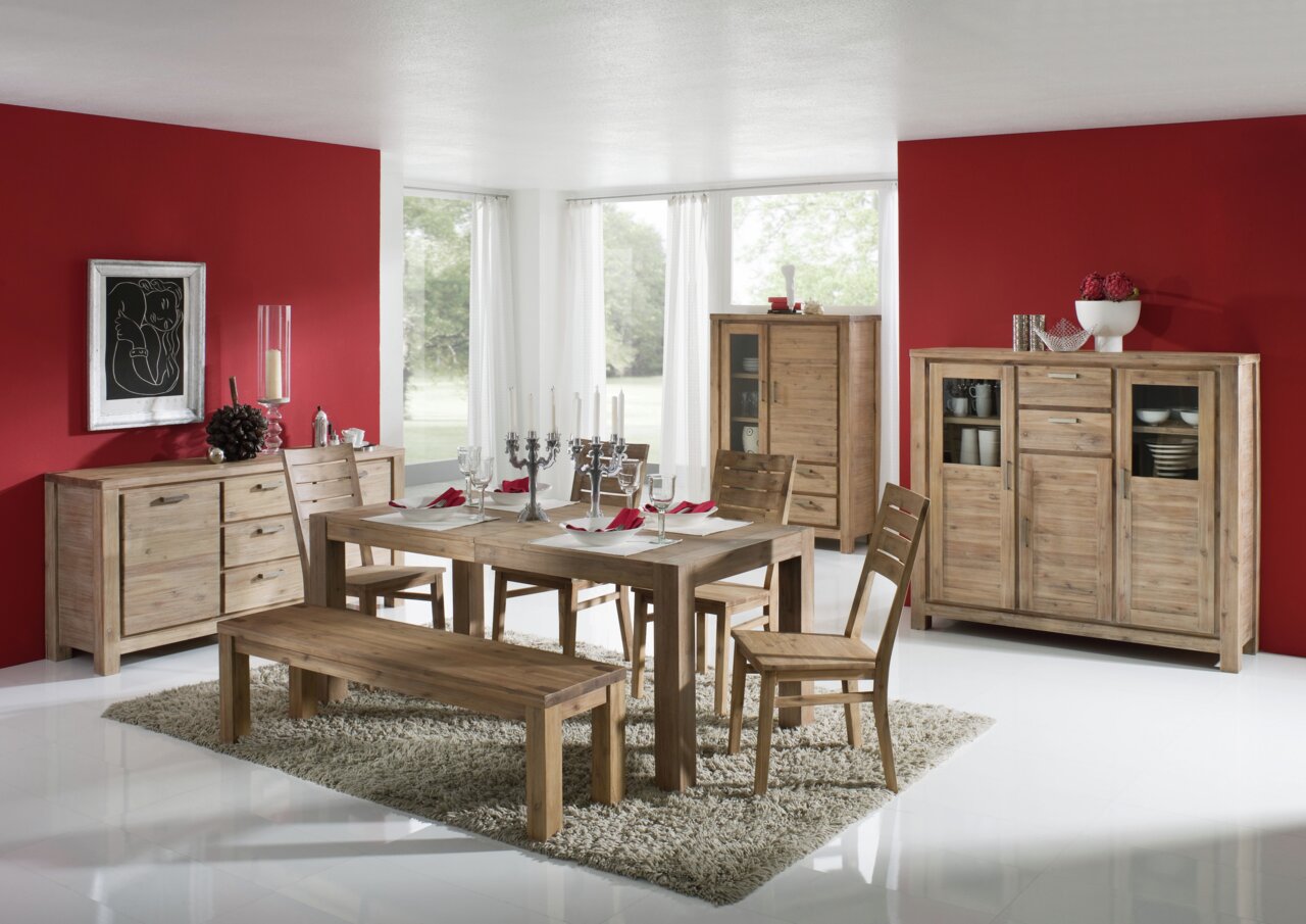 Esszimmer mit Esstisch aus Holz, umgeben von Stühlen und einer Bank, in einem modernen Raum mit roten Wänden und großen Fenstern, Perspektive von vorne.