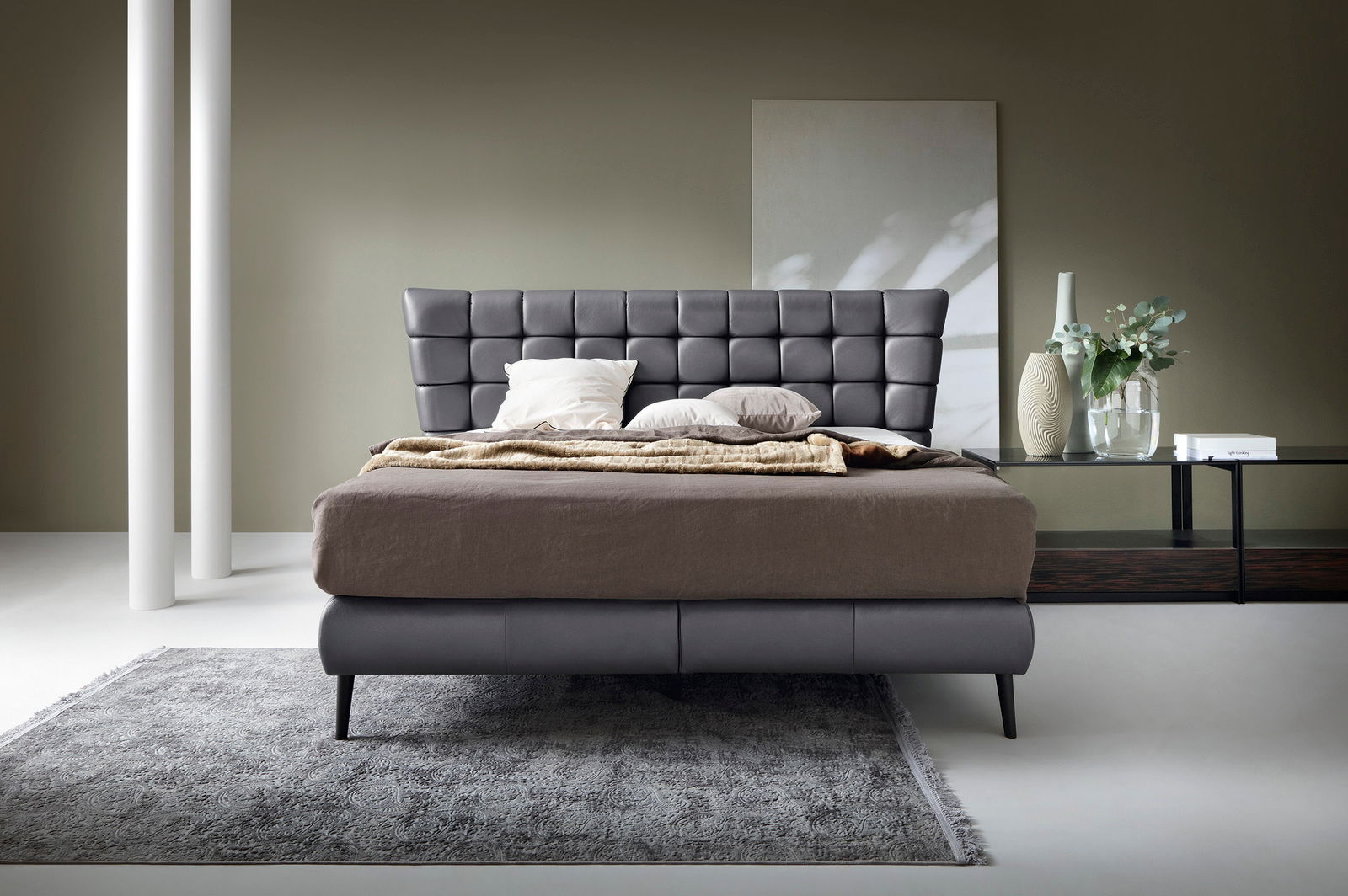 Frontale Ansicht eines modernen Boxbetts mit gepolstertem Kopfteil in einem stilvollen Schlafzimmer.