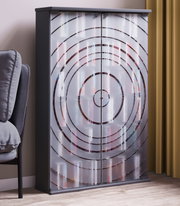 Frontale Ansicht eines modernen Schranks mit schwarzem Korpus und zwei spiegelnden Türen mit konzentrischem Kreis-Design, im Wohnraum neben Sofa und Vorhang.