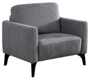 Grijze, gestoffeerde fauteuil met brede armleuningen en zwarte, taps toelopende houten poten, vrijstaand op een witte achtergrond, in een schuin vooraanzicht (3/4-perspectief) vanaf linksvoor.