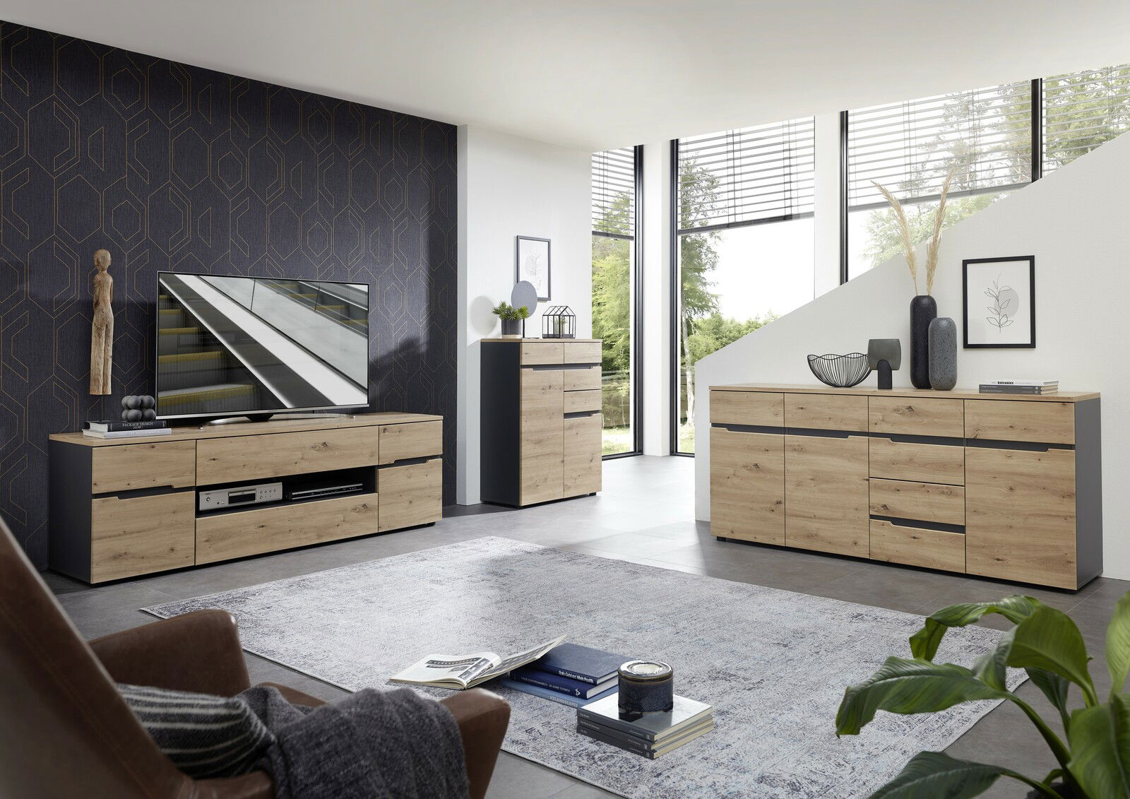 Moderne Wohnzimmermöbel in Holzoptik, bestehend aus einem TV-Lowboard, einem Highboard und einem Sideboard, in einer hellen, stilvollen Umgebung mit Blick auf große Fenster.
