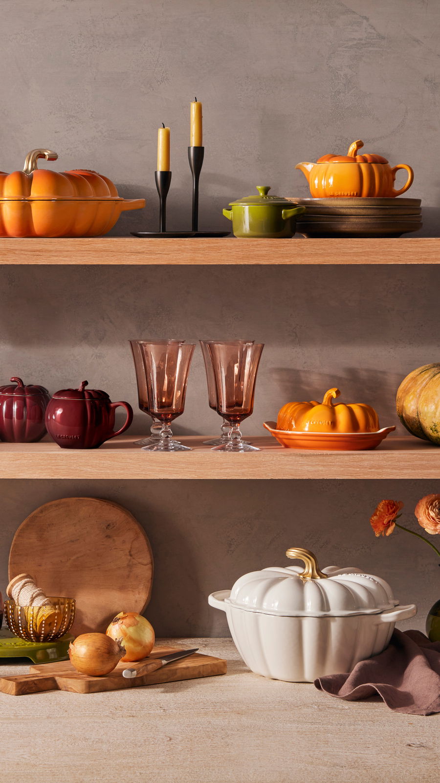 LE CREUSET Kürbis Förmchen 350ml Ofenrot HALLOWEEN Kürbisförmige Keramikschale in Ofenrot auf einem Regal, seitliche Perspektive