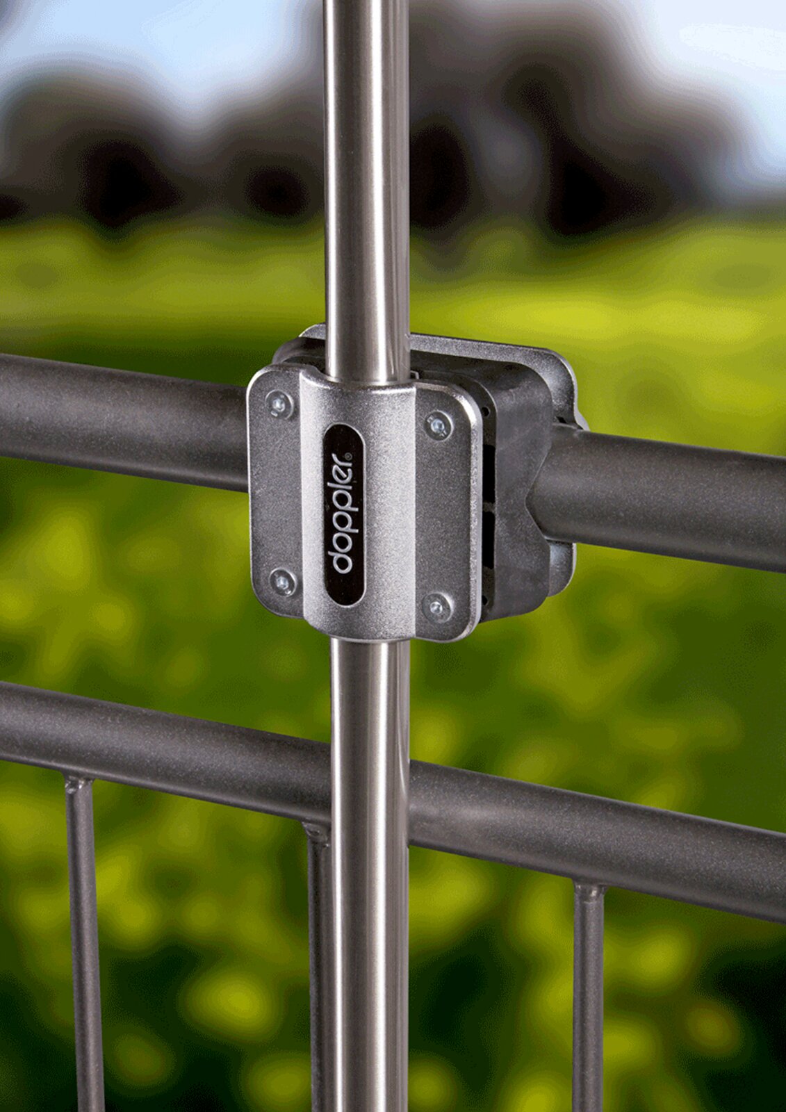 Close-up van een metalen balkonbeugel die aan een reling is bevestigd, met een groene, onscherpe achtergrond.
