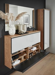 Garderoben-Set mit Holz- und Weißelementen, bestehend aus einem großen Spiegel, einem Schuhschrank mit Klapptüren und einem hohen Schrank. Dekoriert mit Vasen und Kerzenhaltern, seitliche Perspektive.