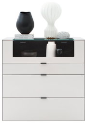 Frontale Ansicht eines modernen weißen Highboards mit drei Schubladen und einer Glasablage, dekoriert mit Vasen und Büchern.