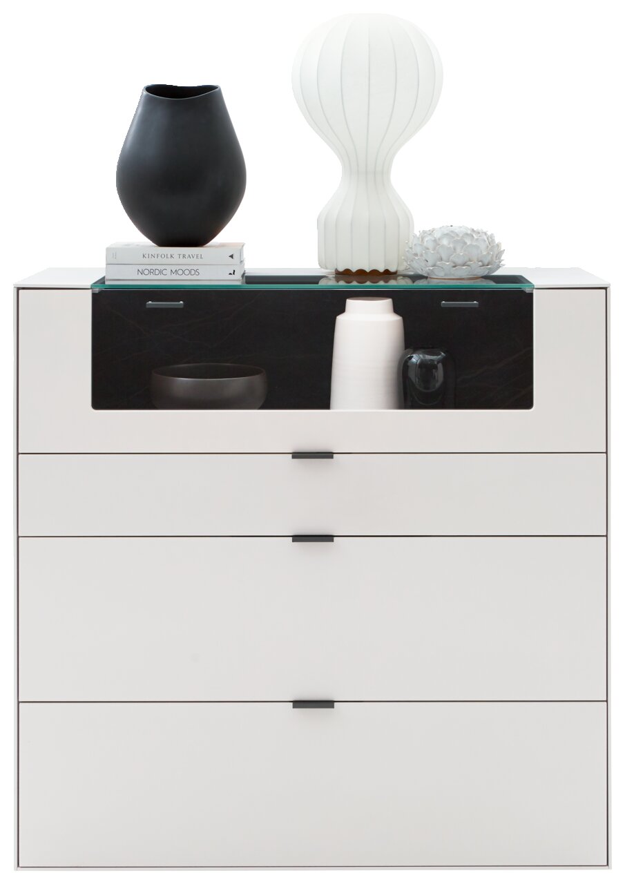 Frontale Ansicht eines modernen weißen Highboards mit drei Schubladen und einer Glasablage, dekoriert mit Vasen und Büchern.