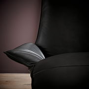 Nahaufnahme einer schwarzen Funktionsliege mit Armlehne, seitliche Perspektive