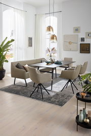 Moderner Esstisch mit schwarzer Tischplatte und beige gepolsterten Stühlen in einem hellen, stilvollen Esszimmer. Perspektive von schräg oben.