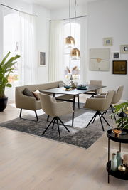 Moderner Esstisch mit schwarzer Tischplatte und beige gepolsterten Stühlen in einem hellen, stilvollen Esszimmer. Perspektive von schräg oben.