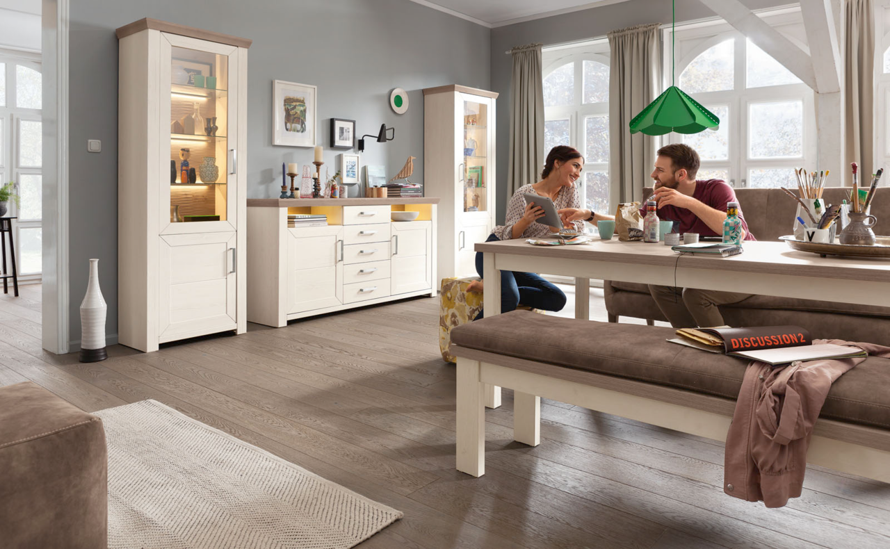 Wohnzimmer mit Esstisch, Bank und Sideboard in heller Holzoptik, seitliche Perspektive