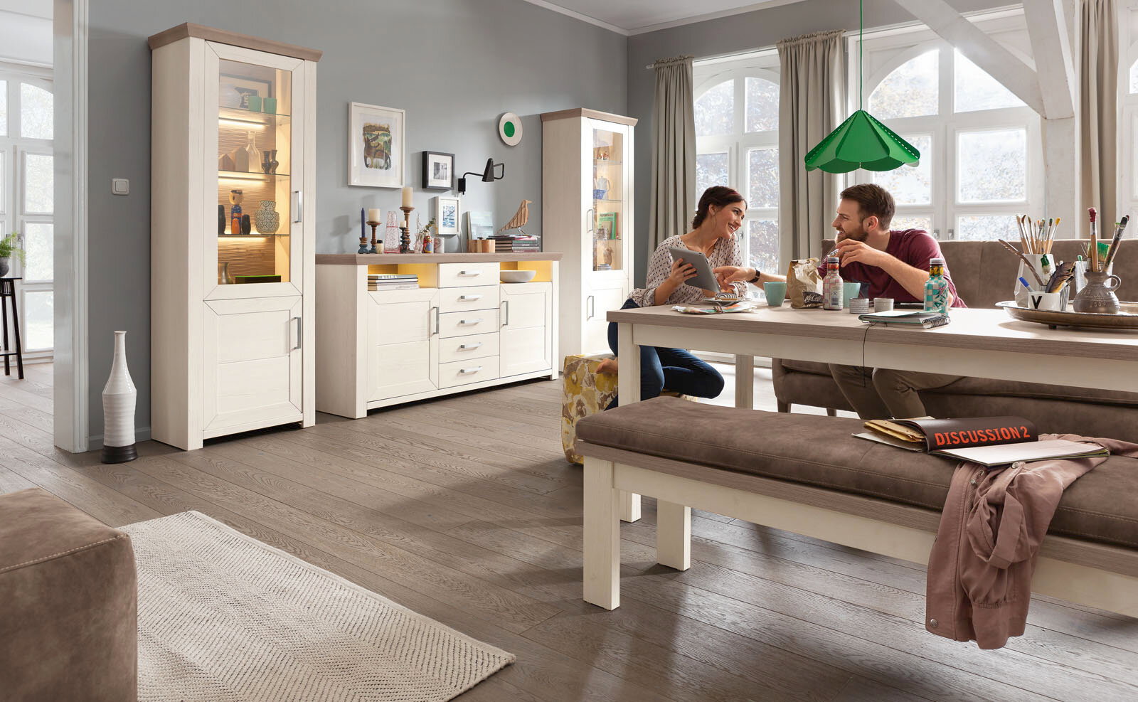 Wohnzimmer mit Esstisch, Bank und Sideboard in heller Holzoptik, seitliche Perspektive