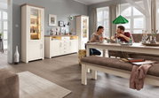 Wohnzimmer mit Esstisch, Bank und Sideboard in heller Holzoptik, seitliche Perspektive